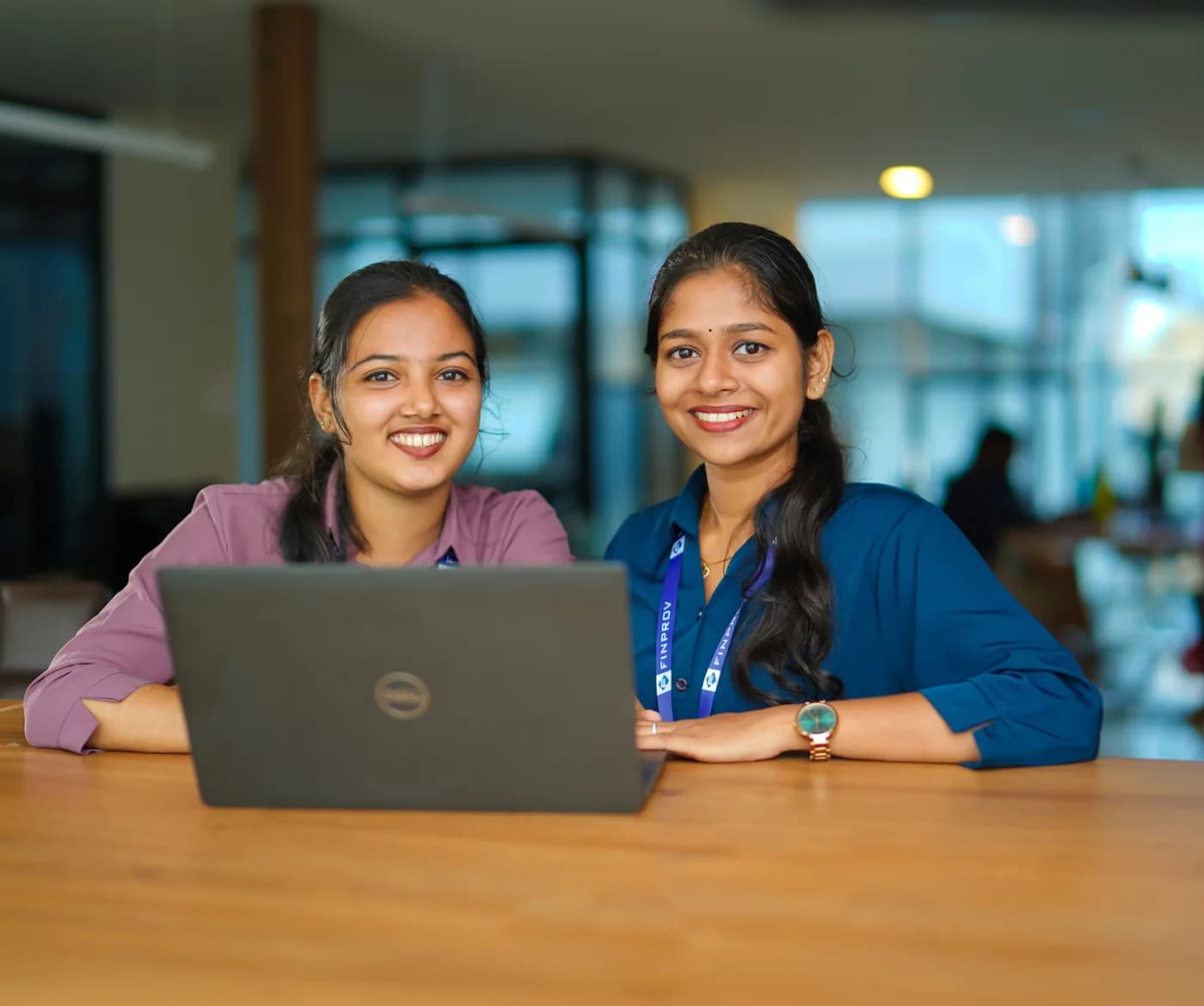 Two Finprov learners smiling at a laptop in a Finprov learning centre
